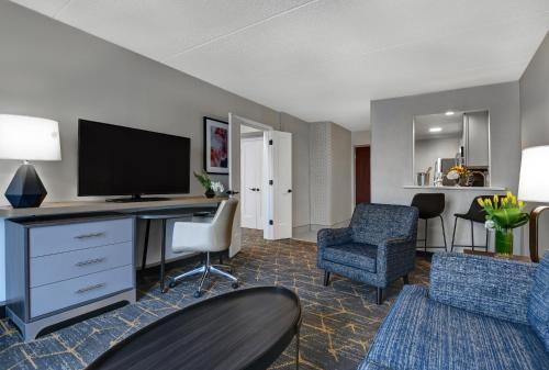 a hotel room with a desk with a television and chairs at Holiday Inn Philadelphia-Cherry Hill, an IHG Hotel in Cherry Hill