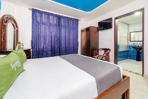 a bedroom with a large bed and a bathroom at Eclipse Villavicencio in Villavicencio