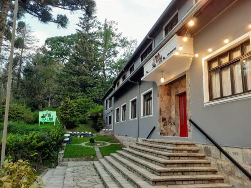 un edificio con escaleras y una puerta roja en Pousada Vista do Lago - HOSTEL, en Gramado