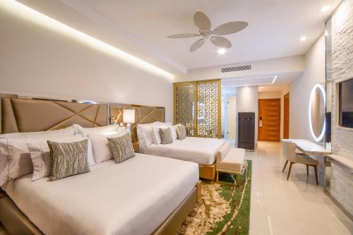 a bedroom with two beds and a living room at Garza Blanca Resort & Spa Los Cabos in Cabo San Lucas