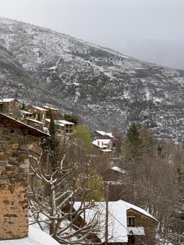 a snow covered hill with houses and a mountain at Casa Rural Pirineu Nevà in Nevà