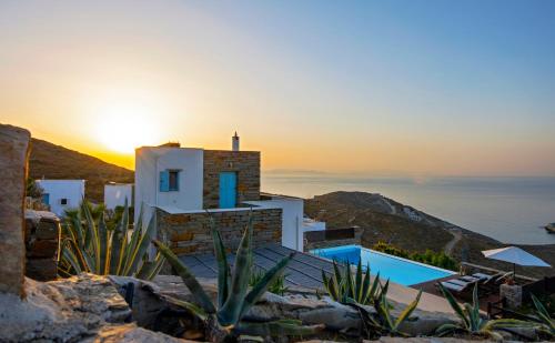 a house on a hill with the sunset in the background at Villa Aqua Marina in Vourkarion