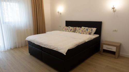 een bed in een slaapkamer met een zwart bedframe en een ventilator bij M Rooms in Boekarest