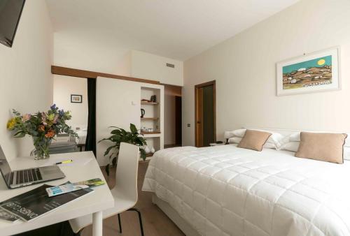 - une chambre avec un lit et un bureau avec un ordinateur portable dans l'établissement Residence Porta Al Prato, à Florence