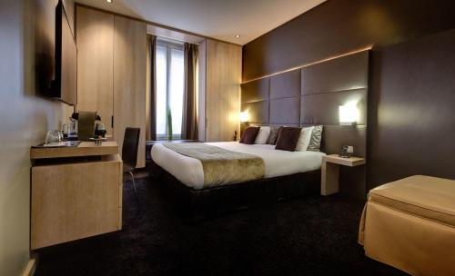 a hotel room with a large bed and a television at Hôtel Elixir in Paris