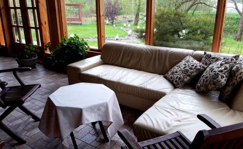 a living room with a couch and a table at Viesu nams Zaļā Sala in Litavniki