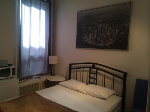 a bedroom with a bed and a picture on the wall at Keppner Guesthouse in Toronto