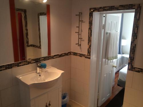 een badkamer met een wastafel en een spiegel bij Keppner Guesthouse in Toronto
