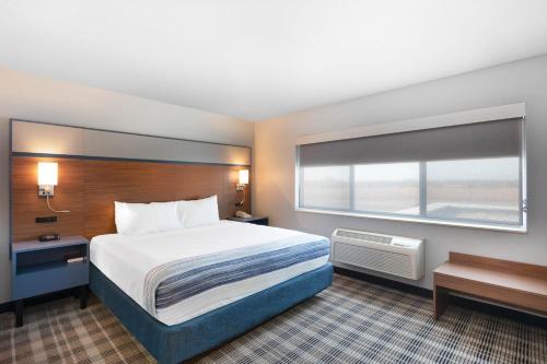 a hotel room with a bed and a window at AmericInn by Wyndham Jackson in Jackson