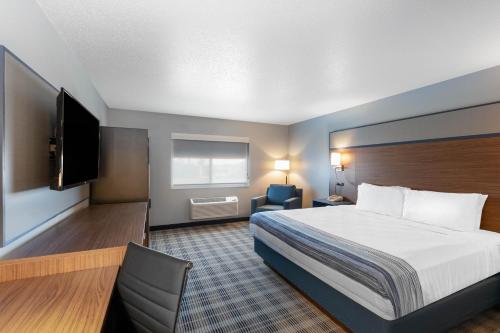 a hotel room with a bed and a flat screen tv at AmericInn by Wyndham Jackson in Jackson