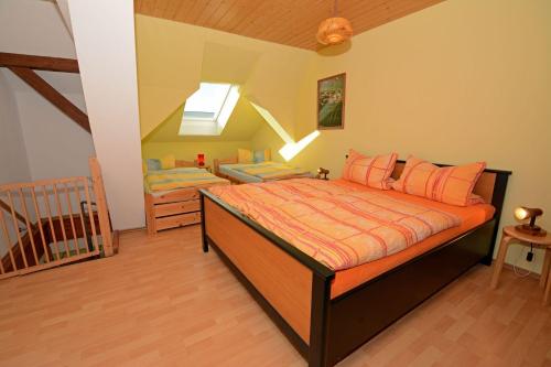 a bedroom with a bed with orange sheets and a staircase at Hof Brinker - Haffblick in Boiensdorf