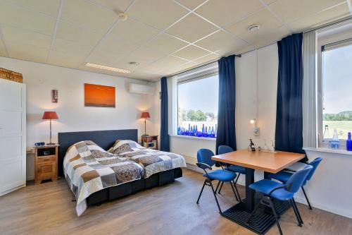 - une chambre avec un lit, une table et des chaises dans l'établissement B & B Leudal, à Haelen