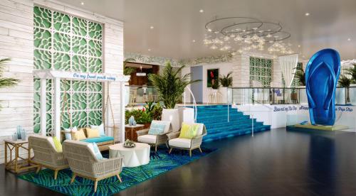 a lobby with chairs and tables and a staircase at Margaritaville Resort Palm Springs in Palm Springs