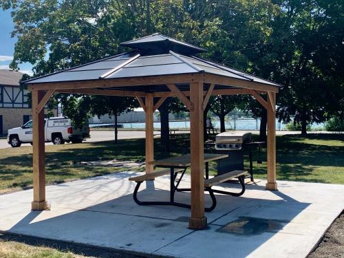 a wooden gazebo with a picnic table and a grill at Days Inn by Wyndham Sarnia Harbourfront in Sarnia