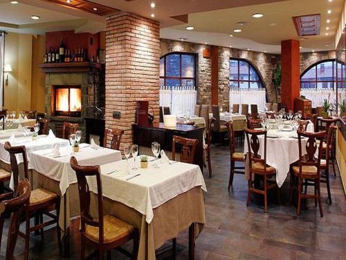 a restaurant with tables and chairs with white table cloth at Hotel Casbas in Senegüé