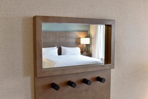 a mirror on a wall with a bed in a room at Staybridge Suites - Waterloo - St. Jacobs Area in Waterloo