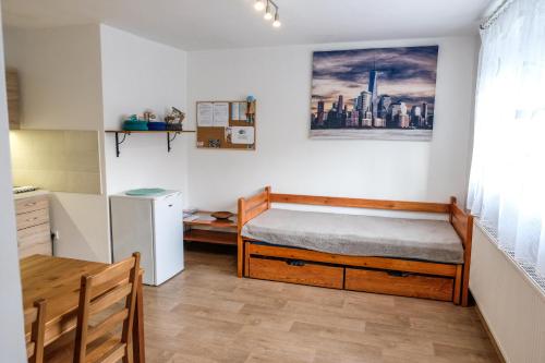 a bedroom with a bed and a table and a refrigerator at Vila Alice in Luhačovice