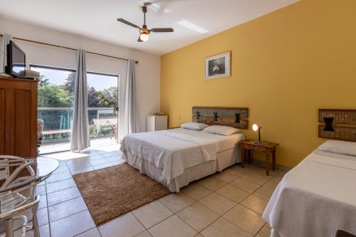 sypialnia z 2 łóżkami i balkonem w obiekcie Pousada Estalagem da Villa w mieście Casa Branca