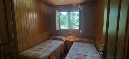 En eller flere senge i et værelse på Cabaña en pleno parque natural del río mundo