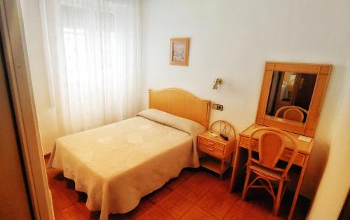 una camera con letto, tavolo e specchio di Hostal Prada a Madrid