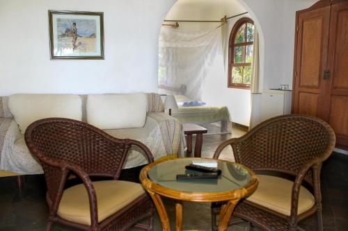 a living room with a couch and chairs and a table at Pousada Colibri in Morro de São Paulo