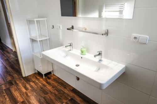 a white bathroom with a sink and a mirror at Vila Alice in Luhačovice