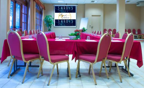 a conference room with a long table with pink chairs at Hotel Erbaluce in Caluso