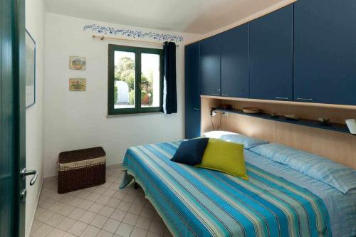 Dormitorio con cama con almohada amarilla en VILLA con PISCINA 200 mt dalla spiaggia 10 persone, en Calasetta