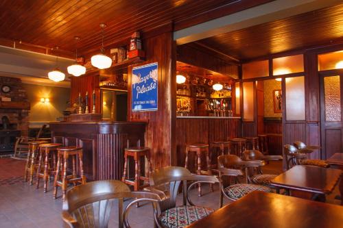 bar z drewnianymi krzesłami i stołami w restauracji w obiekcie Giltraps Townhouse & Glamping w mieście Kinnitty
