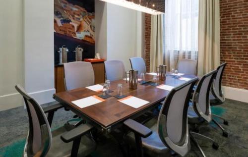 a conference room with a wooden table and chairs at Hotel Indigo Savannah Historic District by IHG in Savannah