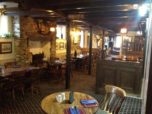 um restaurante com mesas e cadeiras e um bar em The Copley Arms em East Looe
