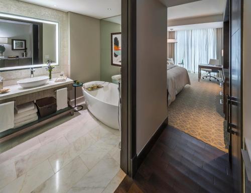 a bathroom with a tub and a bedroom with a bed at InterContinental Real Santo Domingo by IHG in Santo Domingo