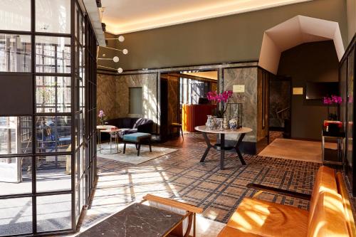 a lobby of a hotel with a table and chairs at Hotel Indigo The Hague - Palace Noordeinde by IHG in The Hague