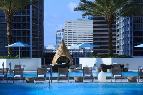 a swimming pool with a swimming pool table and chairs at Kimpton EPIC Hotel, an IHG Hotel in Miami
