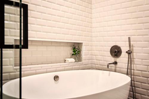 a white bath tub in a white bathroom at Kimpton Hotel Monaco Denver by IHG in Denver