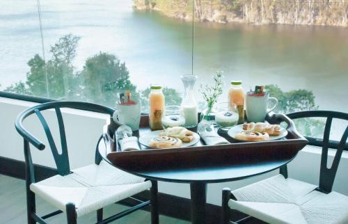 a tray of food sitting on a table with two chairs at Pura Lodge in Concepción