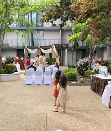 a little girl standing in front of a wedding ceremony at Holiday Inn Dublin - Pleasanton by IHG in Dublin