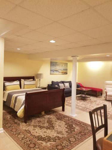 a bedroom with a bed and a couch and a table at Superb Basement close to the Gaylord MGM Outlets National Harbor in Fort Washington