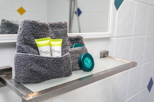 a shelf in a bathroom with two cups on it at Airlie Sun & Sand Accommodation Studio #1 in Airlie Beach