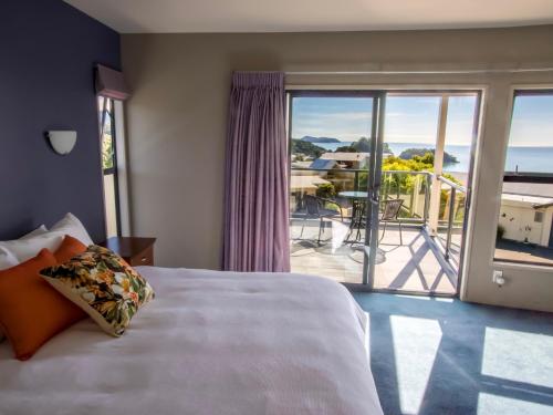 カイテリテリにあるSun, Sea, Sensational - Kaiteriteri Holiday Homeのベッドルーム1室(ベッド1台付)が備わります。バルコニーの景色を望めます。