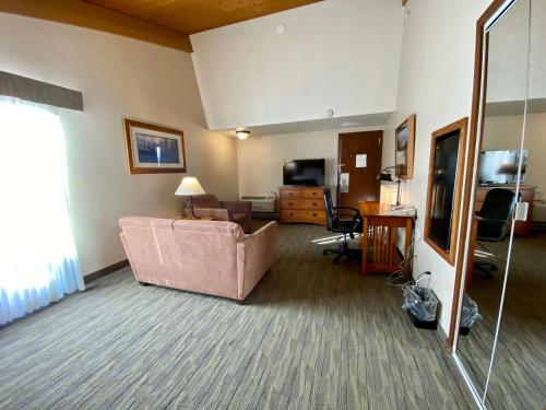 sala de estar con sofá rosa y TV en Best Western Sheridan Center, en Sheridan