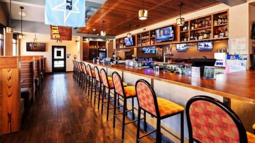 un bar con una fila de sillas en un restaurante en Best Western Sheridan Center en Sheridan