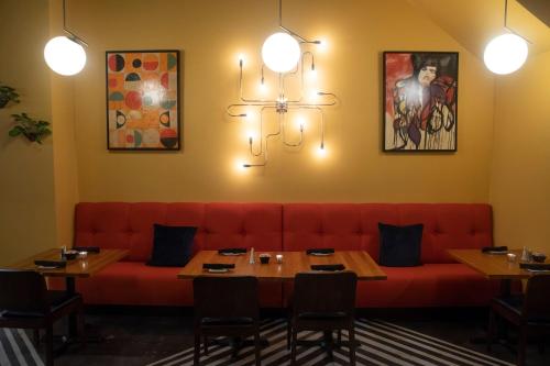 a red couch in a restaurant with tables and chairs at Holiday Inn Lancaster by IHG in Lancaster
