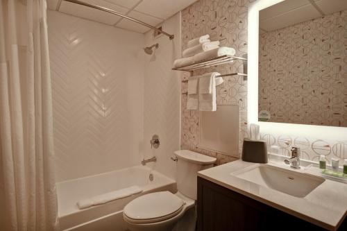 a bathroom with a toilet and a sink and a tub at Holiday Inn Lancaster by IHG in Lancaster