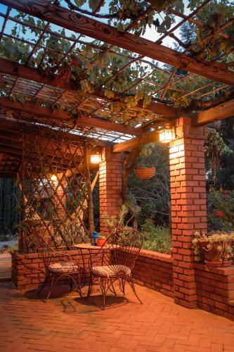 a patio with a table and chairs under a pergola at Quinta Maria en la Ruta del Vino in Valle de Guadalupe