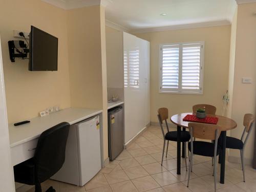 a kitchen and dining room with a table and chairs at Bel Mondo Apartments in Wollongong