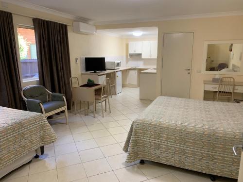 a hotel room with two beds and a kitchen at Bel Mondo Apartments in Wollongong