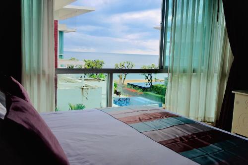 a bedroom with a bed and a view of the ocean at Pool Villa at Vimanlay in Cha Am