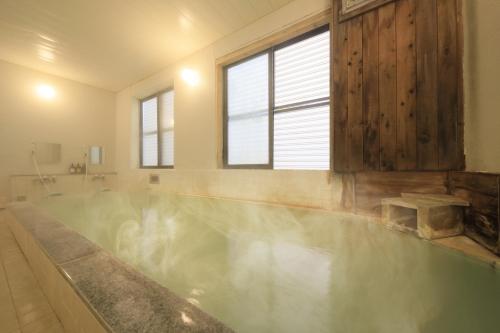 baño con bañera llena de agua en Yumori Kamaya en Nikko