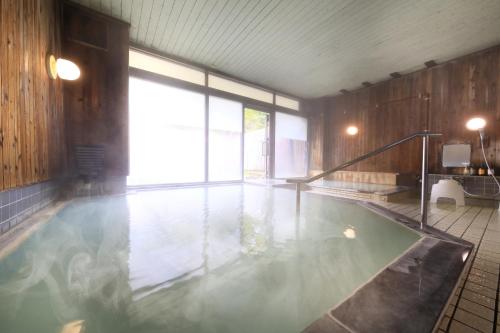 uma piscina com uma grande janela num quarto em Yumori Kamaya em Nikko